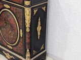 a black and gold cabinet with a marble top in a room