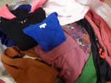 une pile de vêtements dans un panier sur le sol