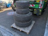 a pile of tires on a pallet next to a garbage truck