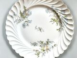 a white plate with blue and green flowers on it