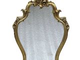 une image d'un miroir encadré d'or sur un mur blanc