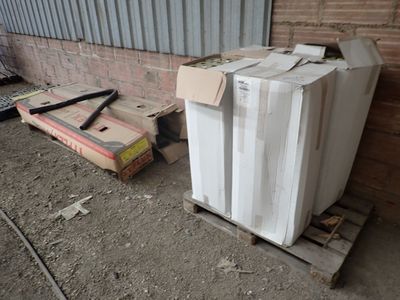 a white refrigerator sitting on top of a pallet next to a brick wall