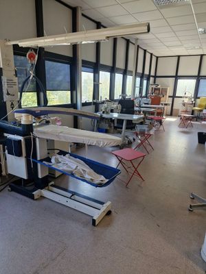 de nombreuses tables et chaises dans une grande pièce dotée de fenêtres