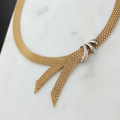 un gros plan d'un collier posé sur une surface en marbre
