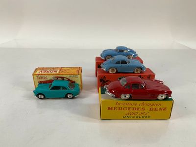 Trois petites voitures sont posées dans une boîte sur une surface blanche
