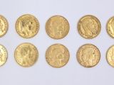 a group of six gold sovereigns on a white surface