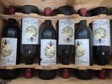 Plusieurs bouteilles de vin sont alignées dans une caisse en bois