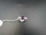 un gros plan d'une bague en or blanc sertie d'une pierre rose
