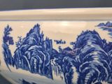 a blue and white bowl with a mountain scene on it