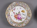 two plates with floral designs on them on a gray surface