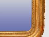 an antique gold framed mirror with a blue background