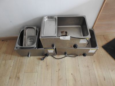 two stainless steel pans sitting on the floor next to each other