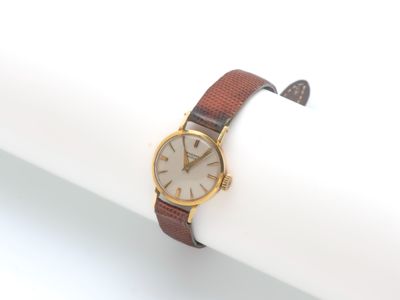 l'image d'une montre posée sur une serviette de table, sur une surface blanche