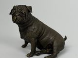 statue représentant un chien noir assis sur une surface blanche