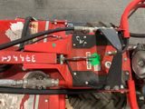 a close up of a red tractor with a hose attached to it
