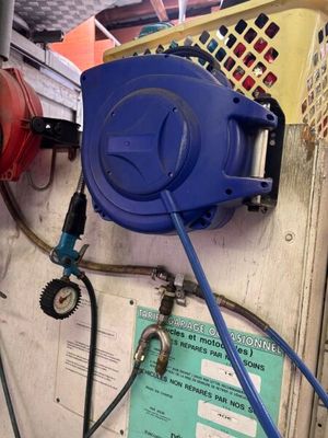 a blue hose attached to a wall next to a blue hose
