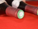 two bottles of wine sitting on a red cloth
