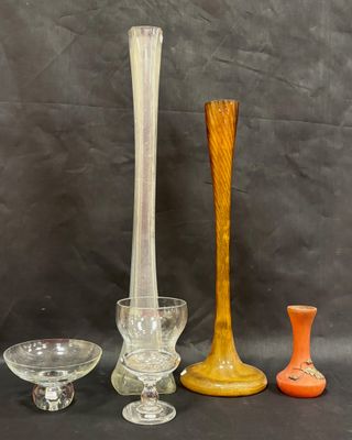 several different colored glass vases and bowls sitting on a table