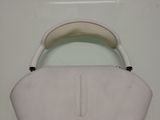a white purse with a black handle on a white surface