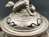 silver plate with a dog on top of it with chinese writing on it
