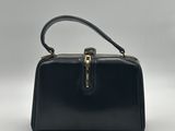 un sac à main en cuir noir avec une poignée dorée