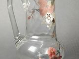 a clear glass pitcher with a floral design on it