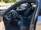 the interior of a car with the door open and the driver ' s seat down