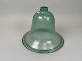 a green glass bell sitting on top of a white table