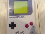 an old game boy sitting on top of a wooden table