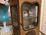 une petite armoire en bois avec une porte vitrée, posée sur une table