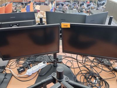 two computer monitors sitting on top of a desk