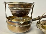 a silver bowl with a spoon and a bowl with a spoon in it