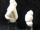 three white sculptures of a bear and a bear cub on a black background
