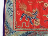an image of a red, blue, and green scarf with a picture of a dragon on it