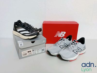 two pairs of new balance running shoes sitting on top of a box