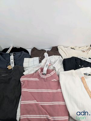 a lot of clothes that are sitting on a bed