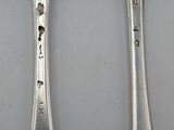 two spoons that are sitting next to each other on a table