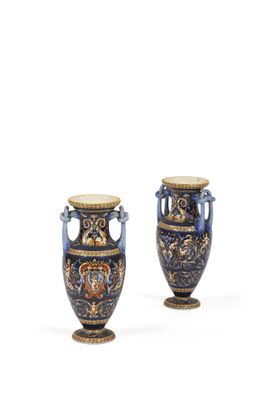 une paire de vases bleus et dorés posés sur une surface blanche