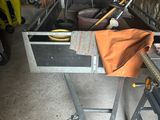un établi sur lequel se trouvent des outils et un sac, dans un garage