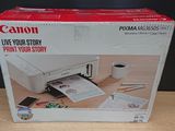 une boîte contenant une imprimante Canon Pixma posée sur une table en bois