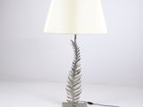 une lampe en forme de fougère argentée avec un abat-jour blanc sur fond blanc
