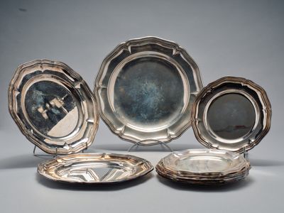 trois assiettes en métal argenté et une assiette en métal argenté sur laquelle est représenté un homme