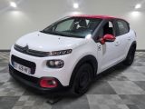 la petite voiture blanche est garée sur un sol en damier