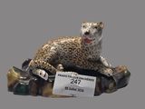 une figurine représentant un léopard assis sur un rocher