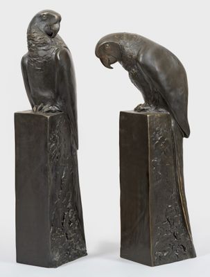 paire de sculptures en bronze représentant des perroquets perchés sur une souche d'arbre