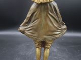 bronze figurine of a woman with a hat and cape