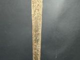 a gold colored sword with a black handle on a black background
