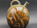 a vase with a painting on it sitting on a table