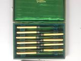 a green box with a set of six knives and a knife sharper
