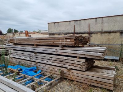 a pile of wood sitting on the ground in front of a building